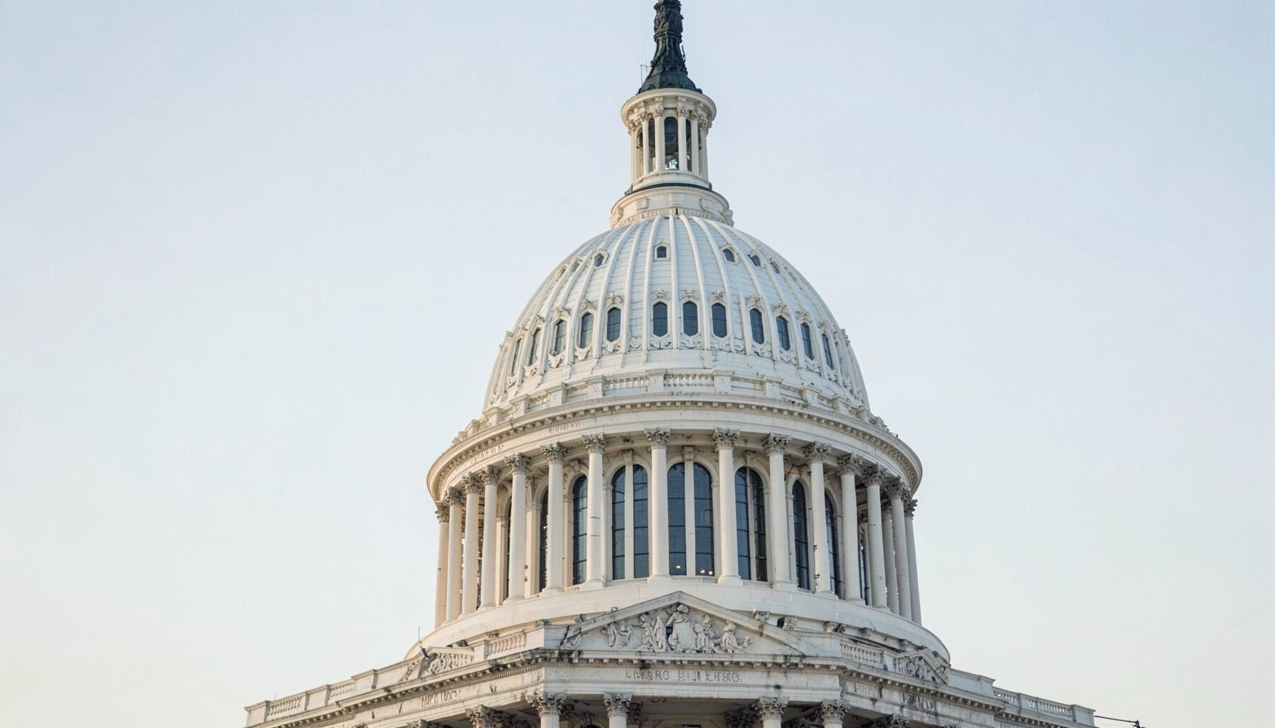 Capitol building dome against a pale sky, conveying federal policy and legislative action